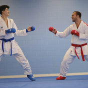 Blue and red competition belts tied on white martial arts gi uniforms