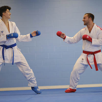 Blue and red competition belts tied on white martial arts gi uniforms