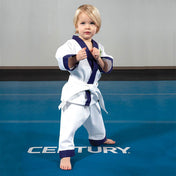 Toddler in white martial arts gi with purple trim and green dragon emblem