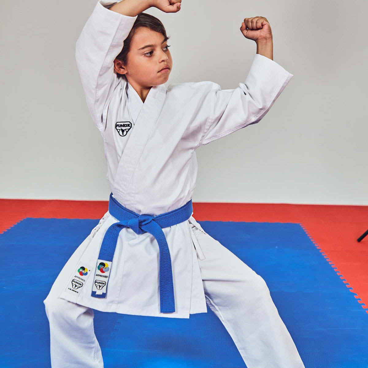 White martial arts uniform with blue belt, long sleeves and wrap-style jacket