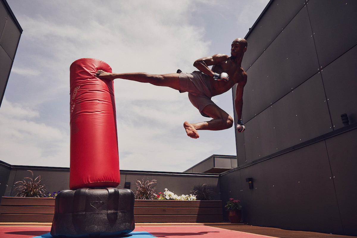 Red inflatable punching bag on a black base, outdoor training setup