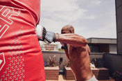 Red inflatable training bag with arm striking it, showing black-and-white wrist strap
