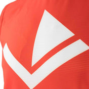 Red sleeveless tee close-up with large white V chevron logo across chest.