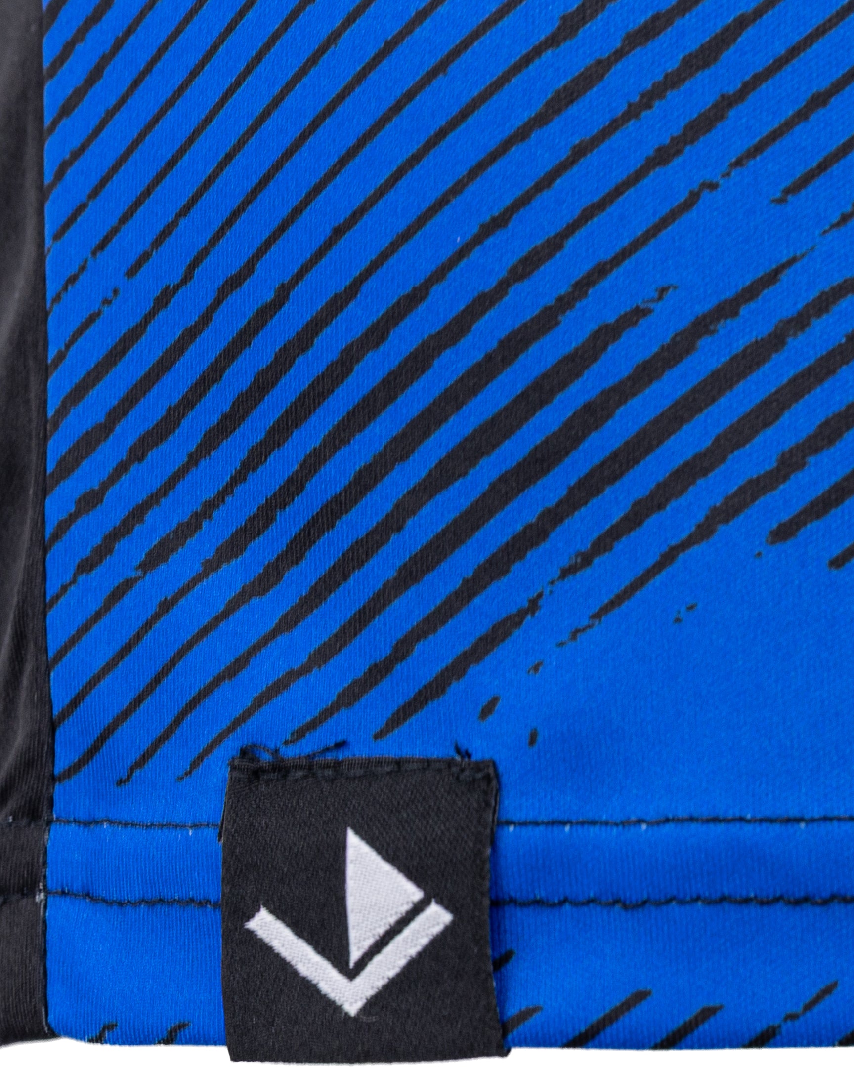Blue patterned athletic tee fabric close-up with black streaks and small logo patch