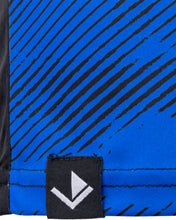 Blue patterned athletic tee fabric close-up with black streaks and small logo patch