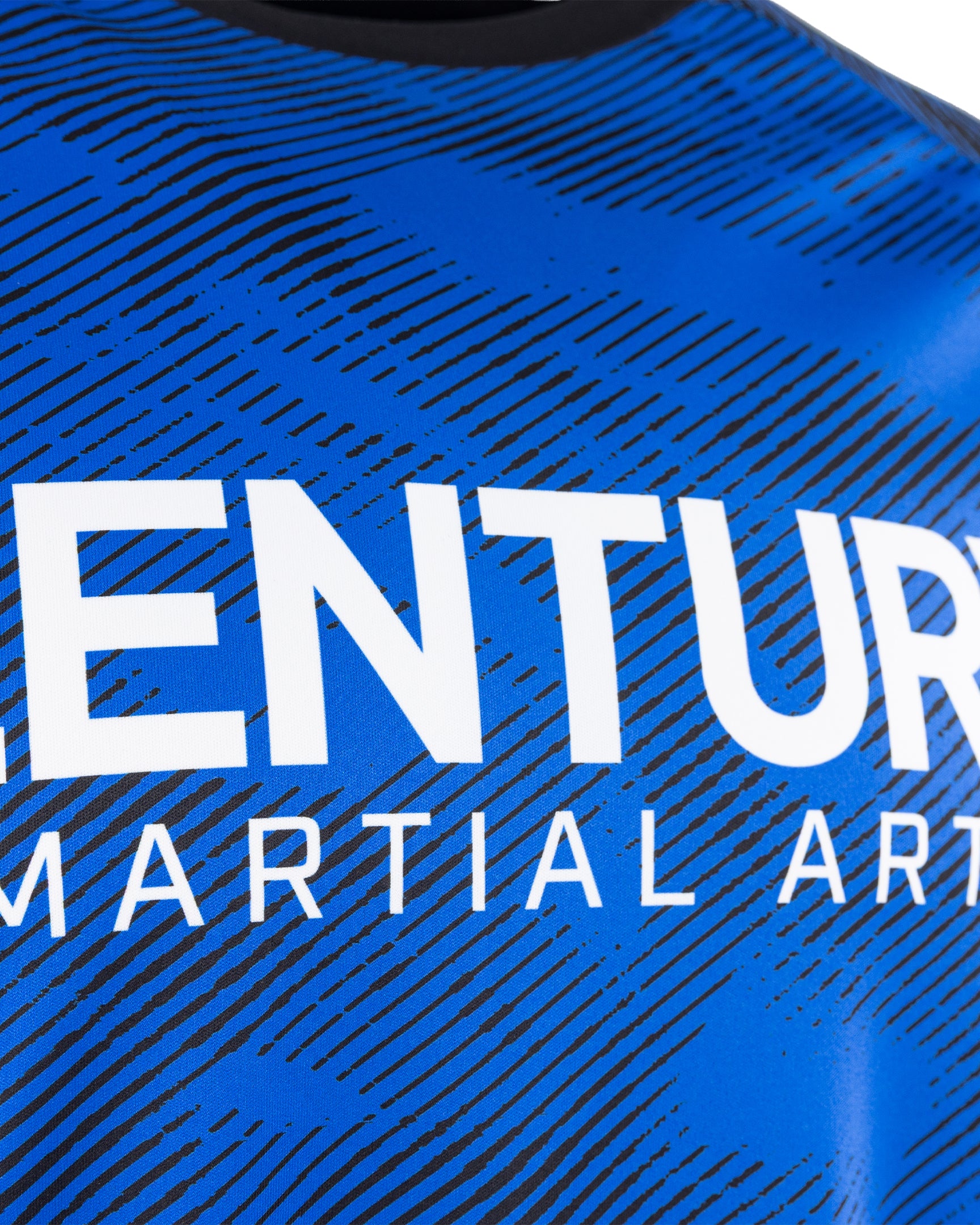 Close-up of blue patterned tee chest print reading CENTURY MARTIAL ARTS
