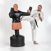 Black padded jacket on mannequin with molded arm guards, paired with white martial outfit