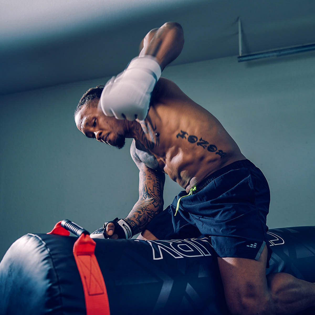 Punching training bag with black graphic panels and red corner strap