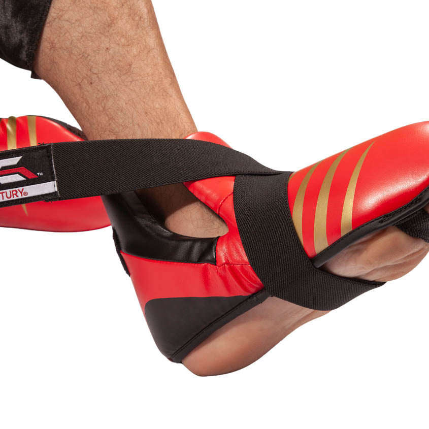 Red and black kickboxing kick pads with hook-and-loop ankle strap and striped side panels