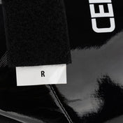 Black boxing kick boot with white label patch and glossy protective front panel