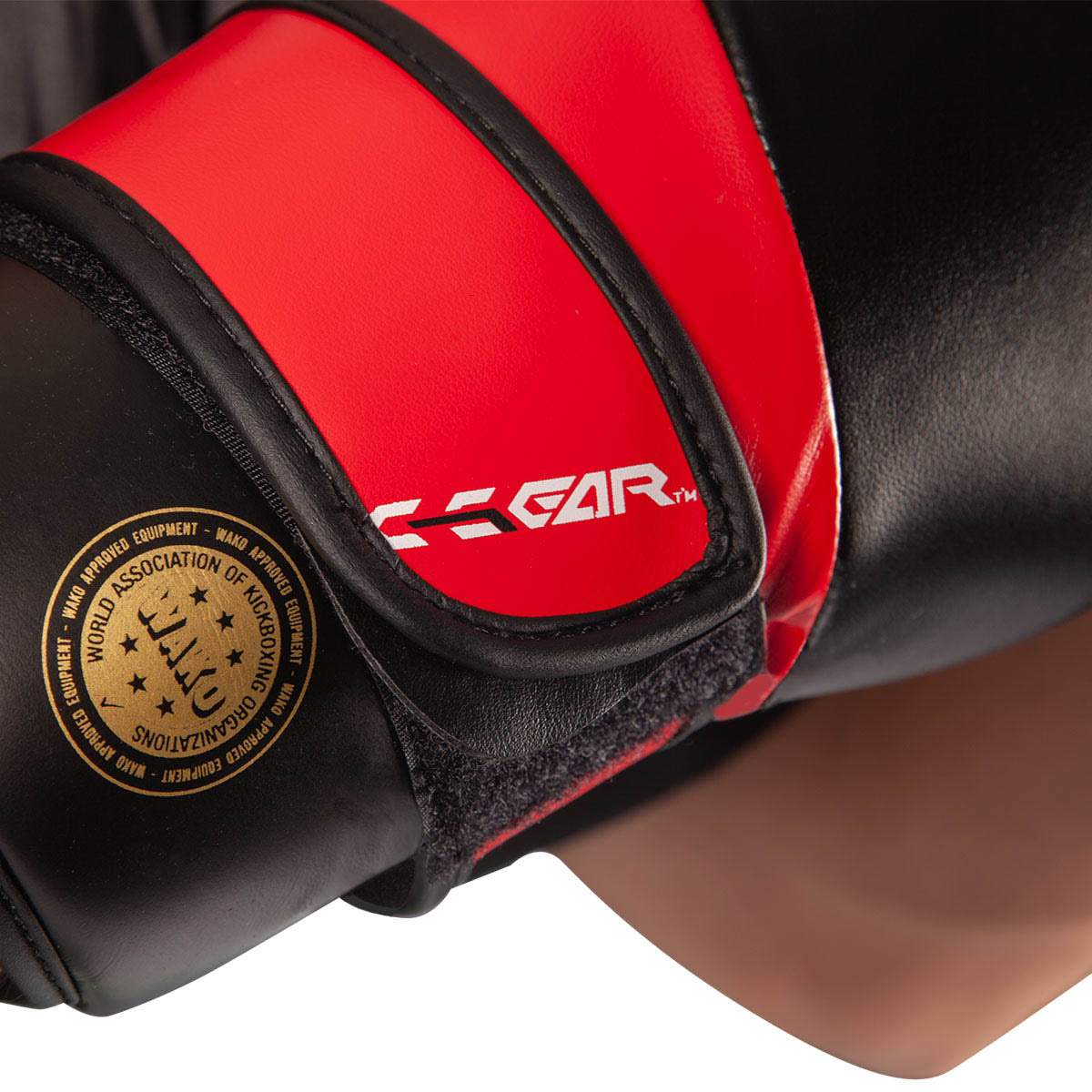 Black boxing glove close-up with red cuff, X-Gear logo, and gold wrist patch