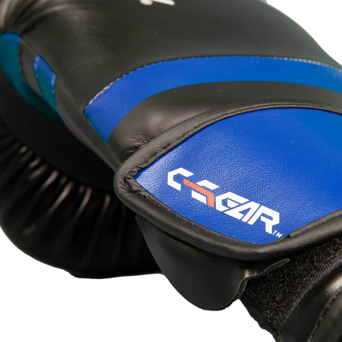 Close-up of a black and blue kickboxing glove showing the C-Gear branding on the pad.