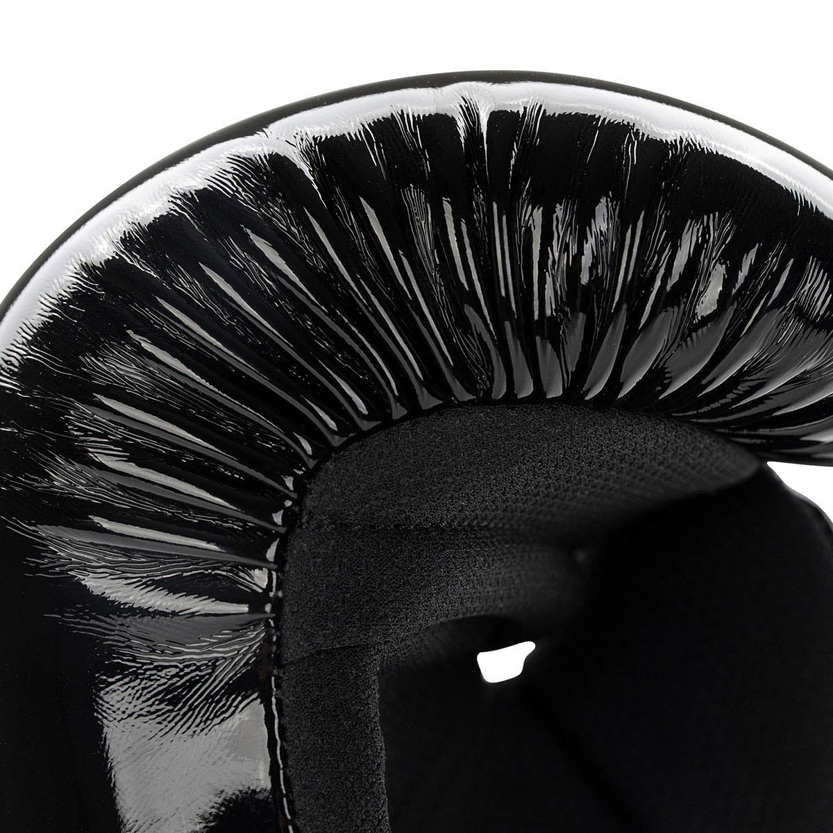 Black boxing glove close-up of shiny curved shell and textured padding near thumb