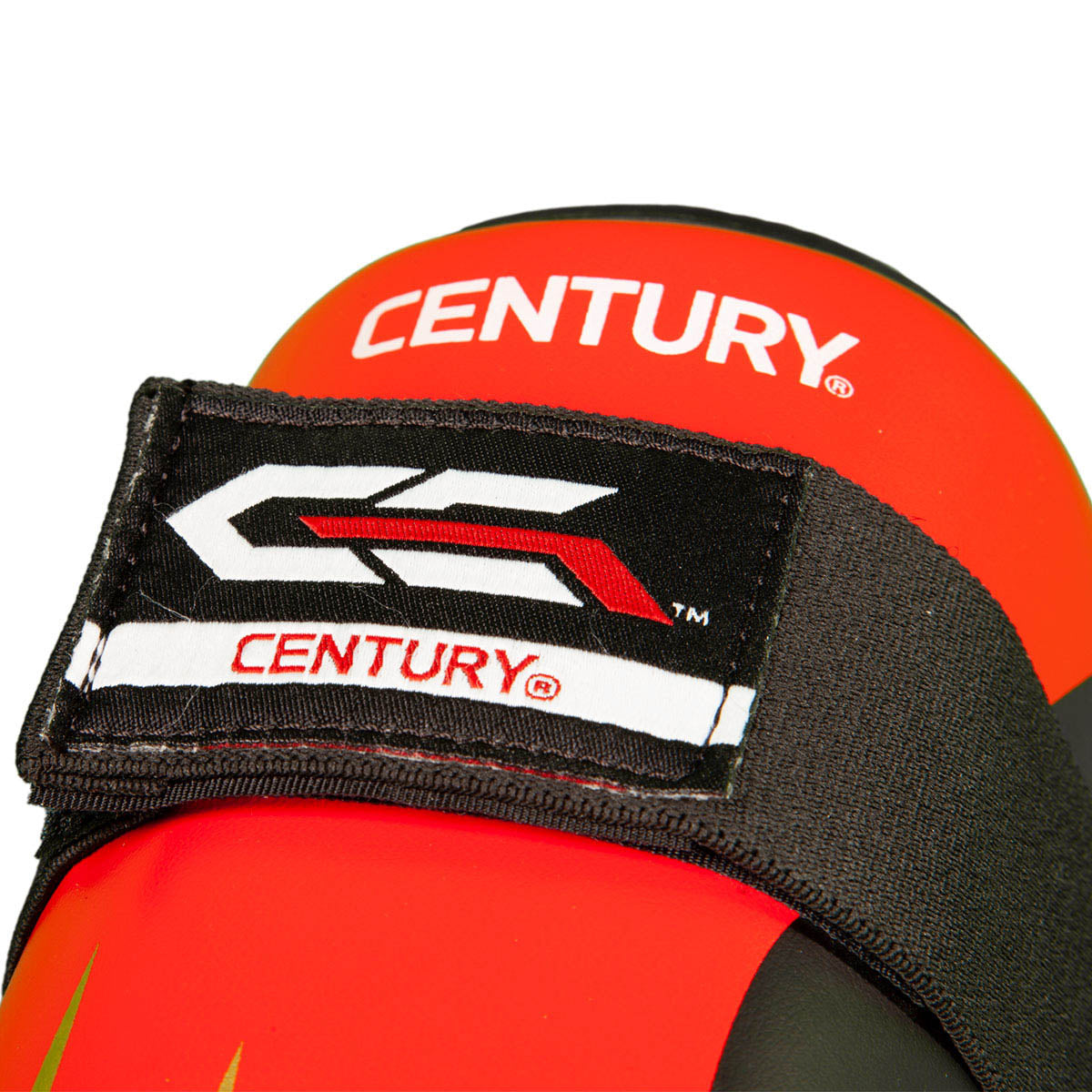 Red shin guard top close-up with CENTURY logo and stitched hook-and-loop strap