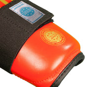 Red boxing shin guards with black fabric straps and padded shell