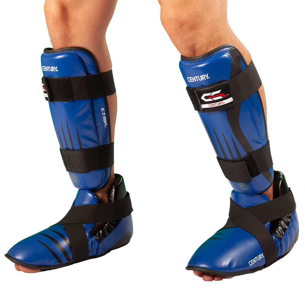 Blue boxing shin guards worn on legs with wide black fastening straps