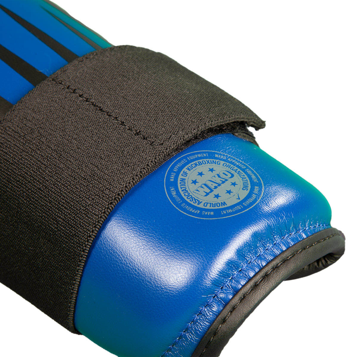 Blue boxing shin guard close-up with round logo on padded shell