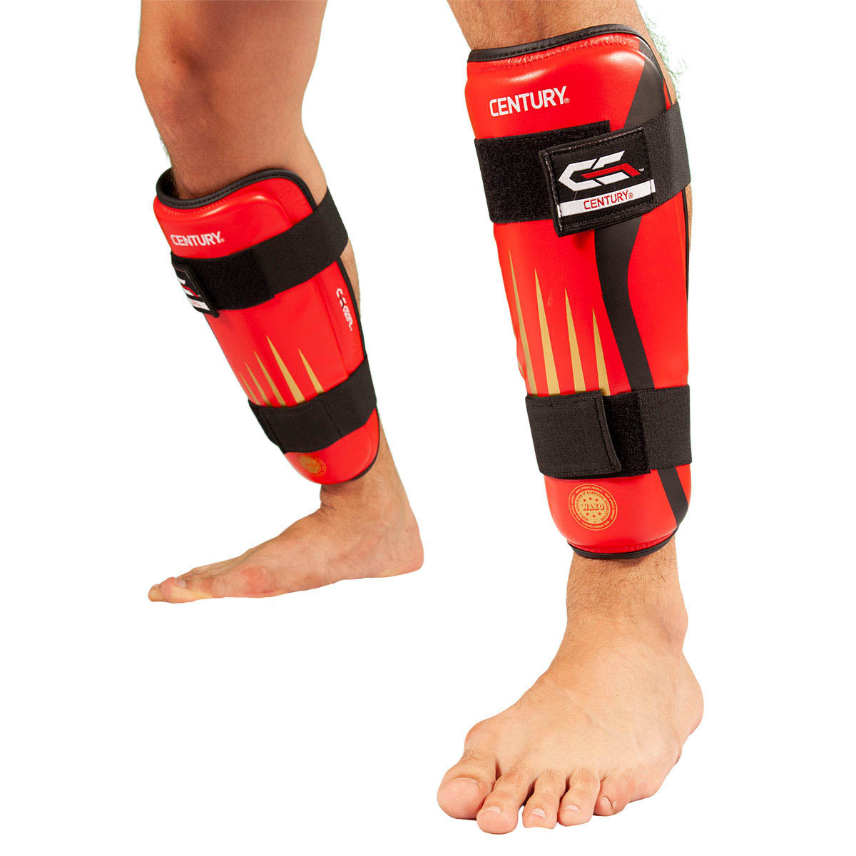Red and black shin guards worn on lower legs with wide fastening straps