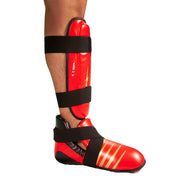 Red shin guard worn on lower leg with black straps and contoured padded shell
