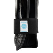 Black shin guards with textured shell, wide fabric strap, and approved label detail