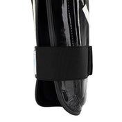 Black shin guards with wide fabric strap and glossy shell, side close-up