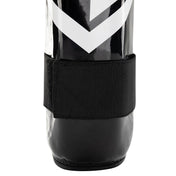 Black shin guards with wide bottom strap and chevron logo on the shell