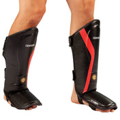 Pair of black shin instep guards with red stripe and adjustable side straps
