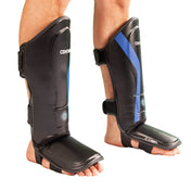 Black shin instep guards with blue stripe, padded footplate, and side closures