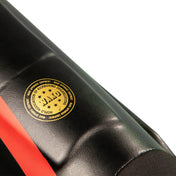 Black shin instep guard with red stripe and yellow round logo on the side