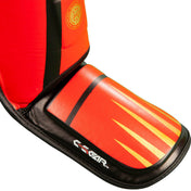 Red shin and instep guard with black strap and orange-yellow stripe graphic