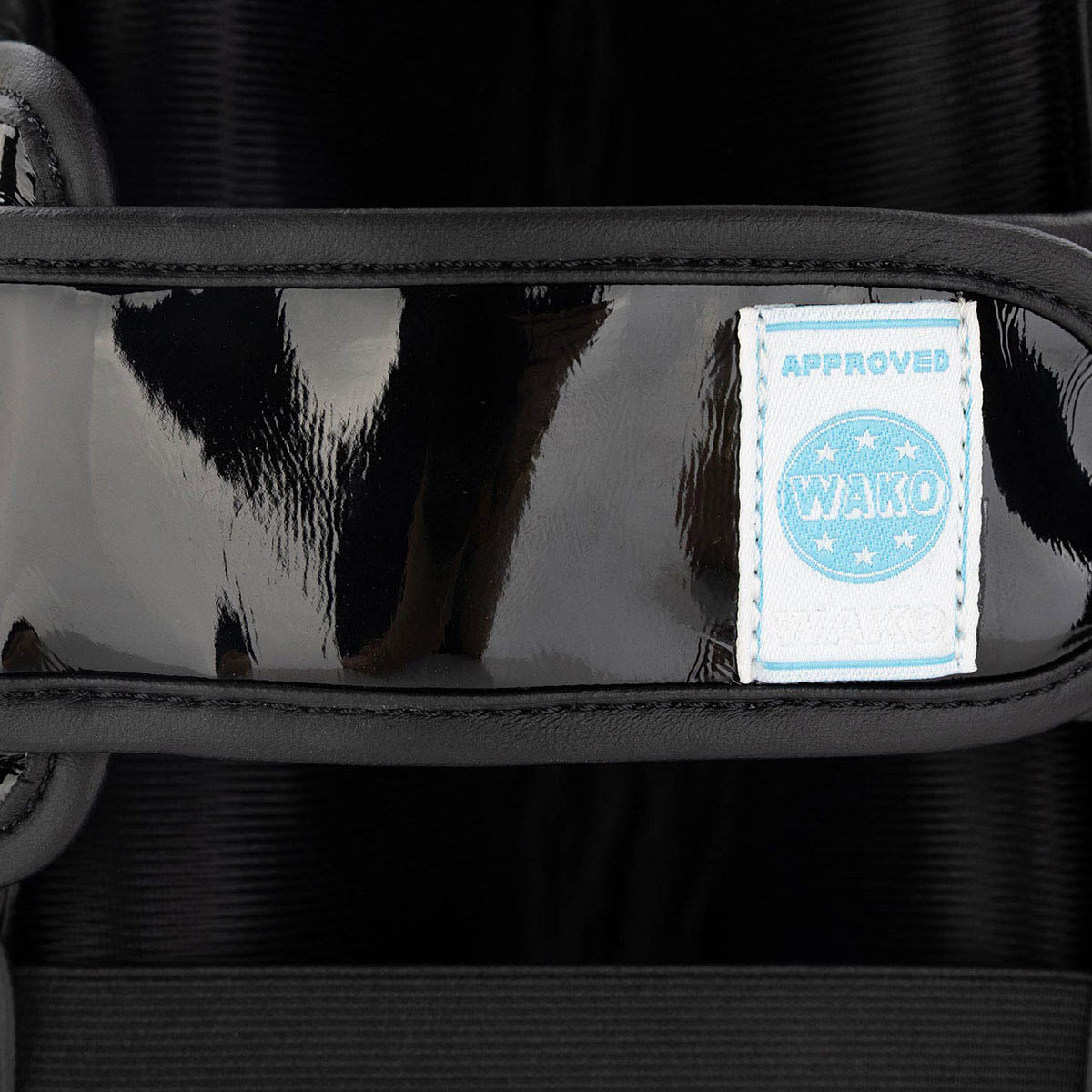 WAKO Valor shin guards strap patch with “WAKO” logo on glossy black