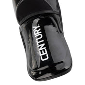 WAKO Valor shin guards, close-up of black glossy shell with vertical “WAKO”