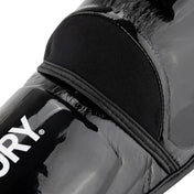 Black glossy shin guards, rounded edges, V logo, hook-and-loop strap detail