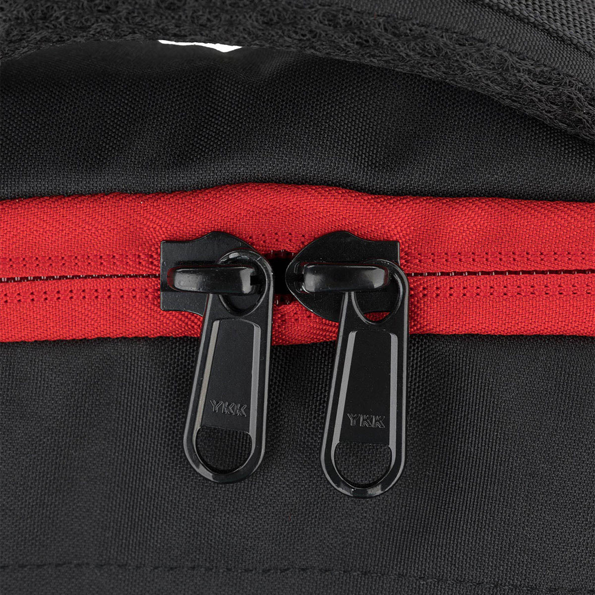 Kumite backpack zipper close-up with YKK pull tabs and red zipper strip