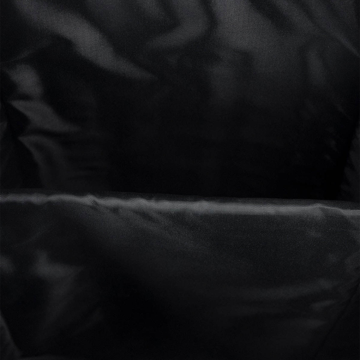 Black backpack interior fabric panel and seam close-up