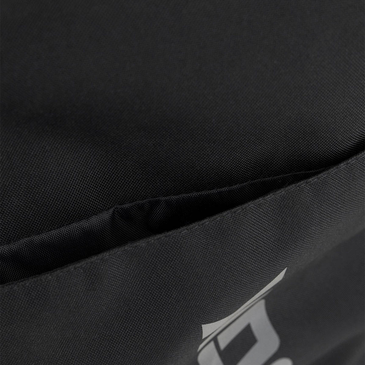 Kumite backpack close-up of black fabric with small diagonal logo detail