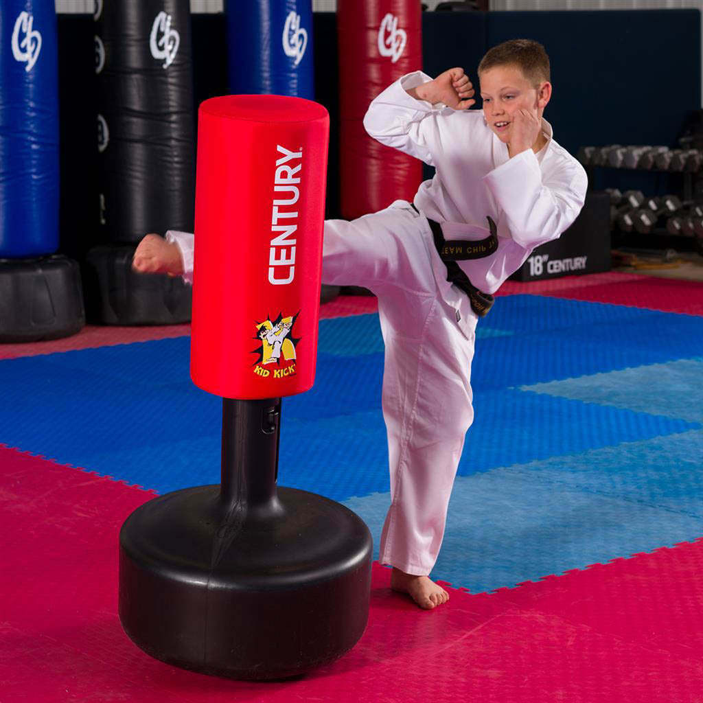 Kids red kick training shield with black base, with child in white martial arts gi