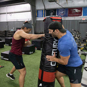 Black cylindrical Versys VS.1 training bag with red panel and padded base.