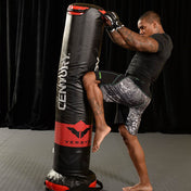 Black Versys VS.1 training bag with red base and logo, set up for kicking drills.