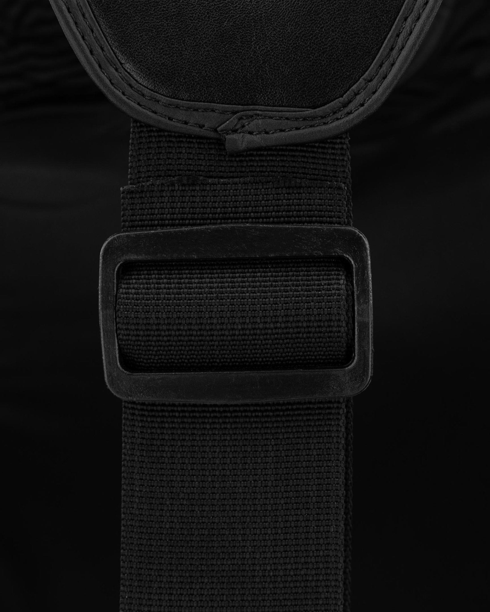 Black belly pad fastening strap with rectangular hook-and-loop patch close-up