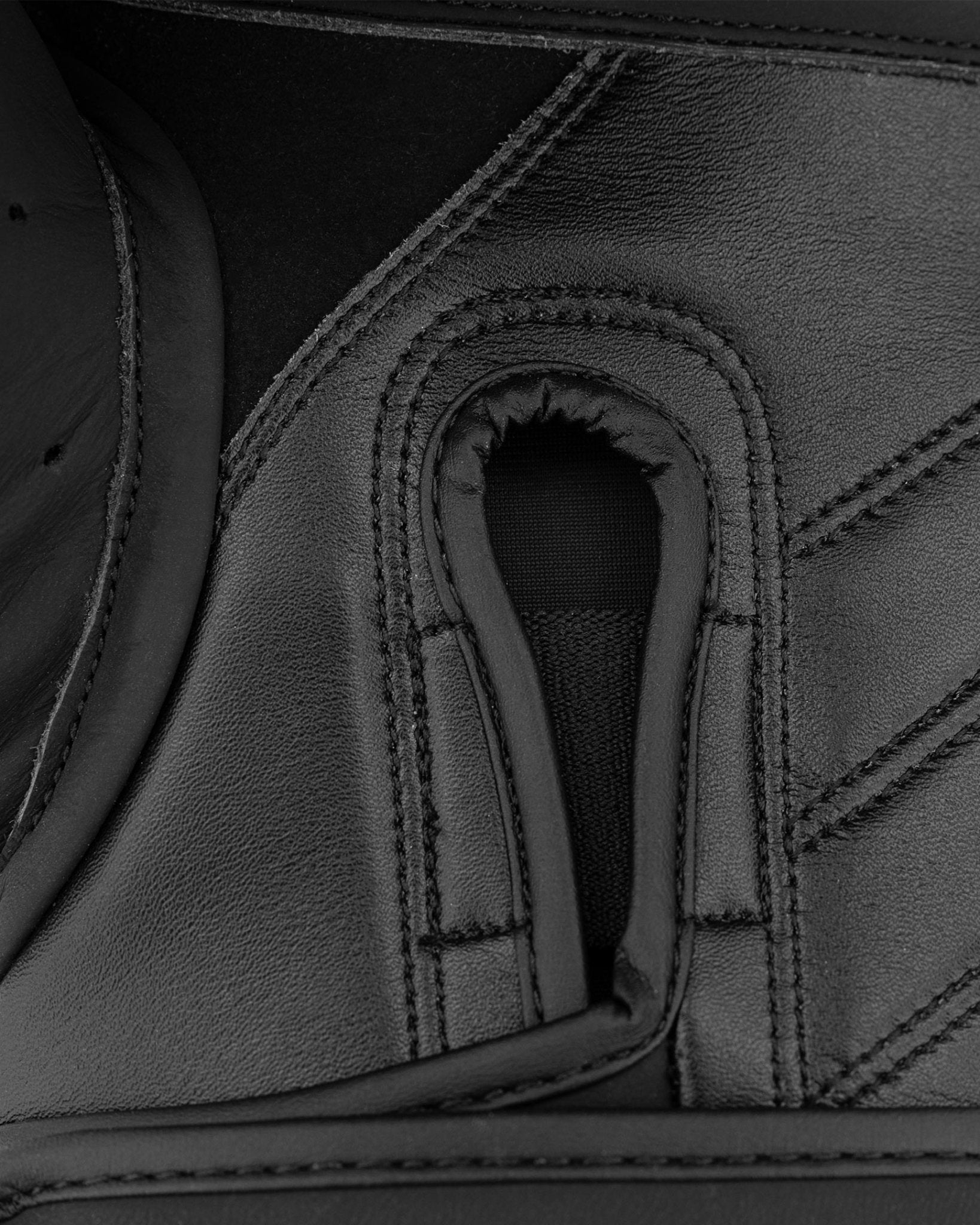 Close-up of black glove interior grip pocket and stitched leather panels