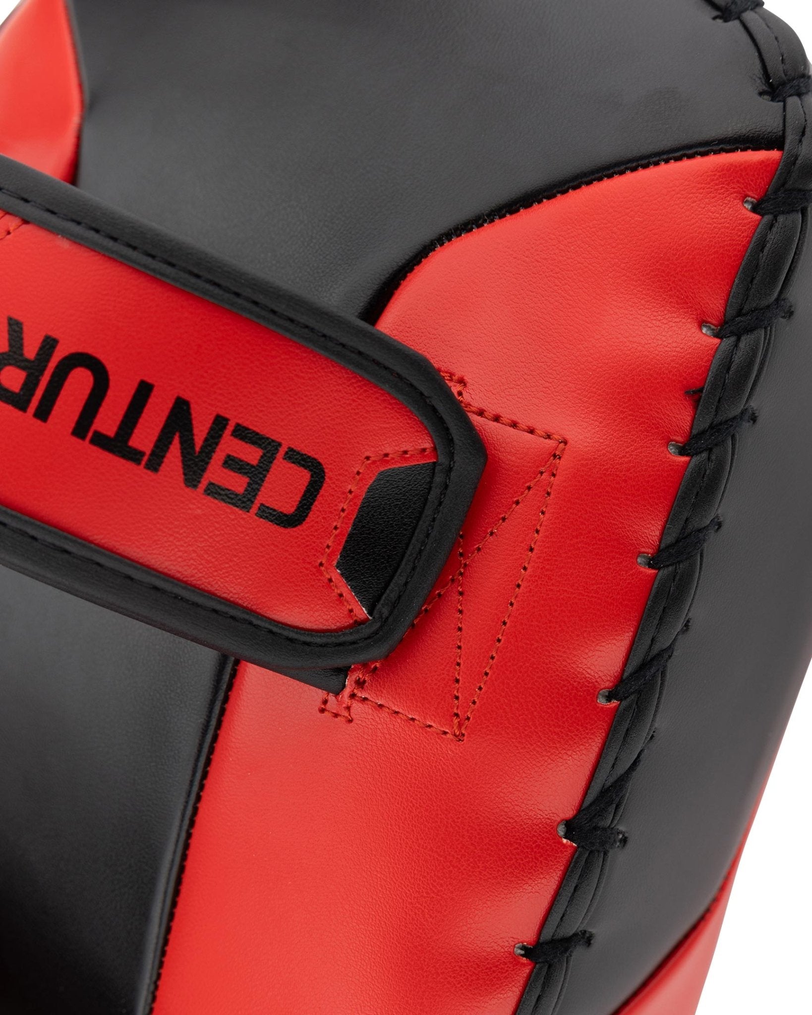 Close-up of red and black Muay Thai pad with wide hook-and-loop wrist strap