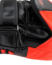 Close-up of black leather wrist wrap with metal ring and red foam edge on focus mitt