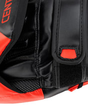 Close-up of black wrist panel, red accent square, and textured grip on focus mitt