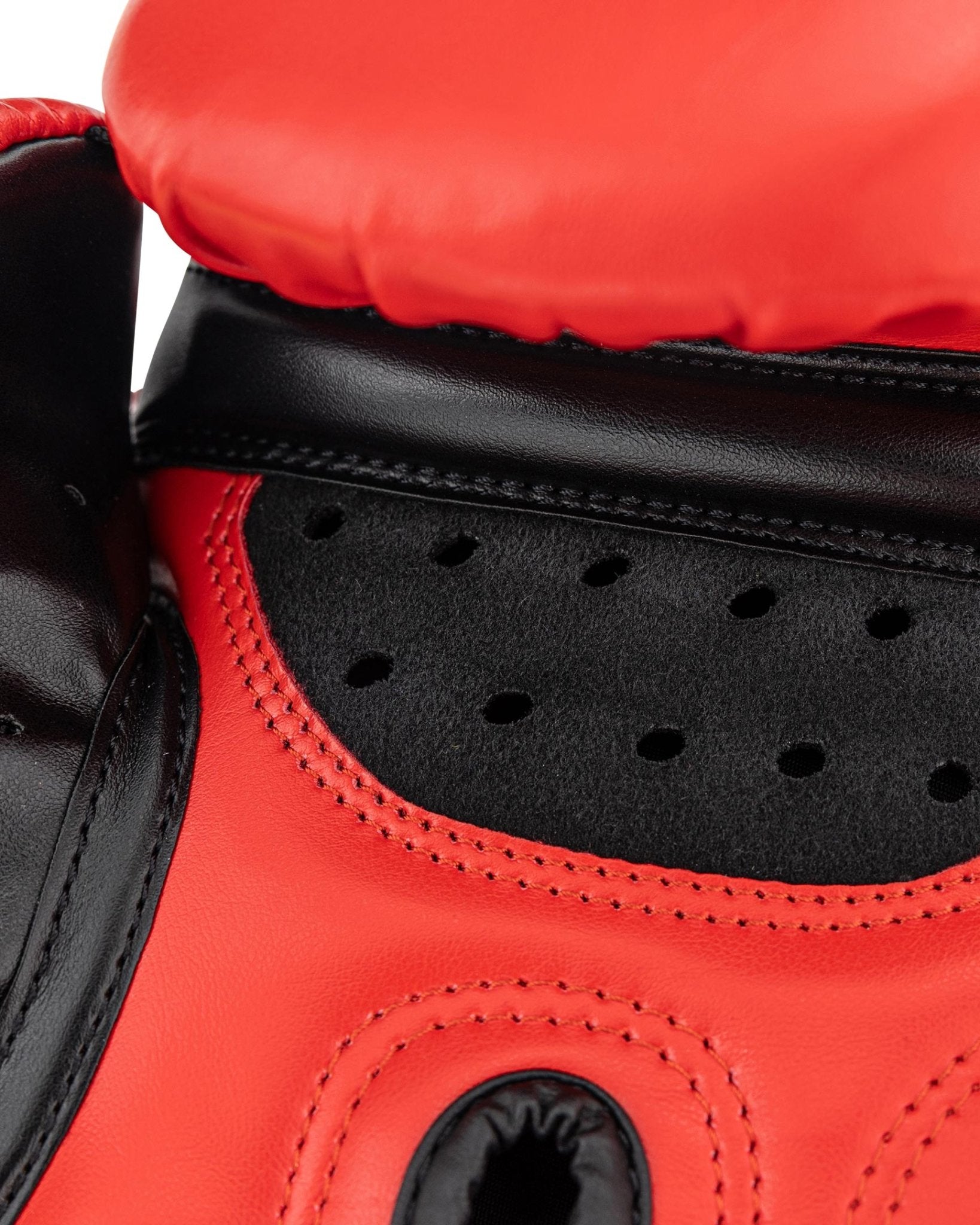 Close-up red glove padding with perforated black insert and stitched seams
