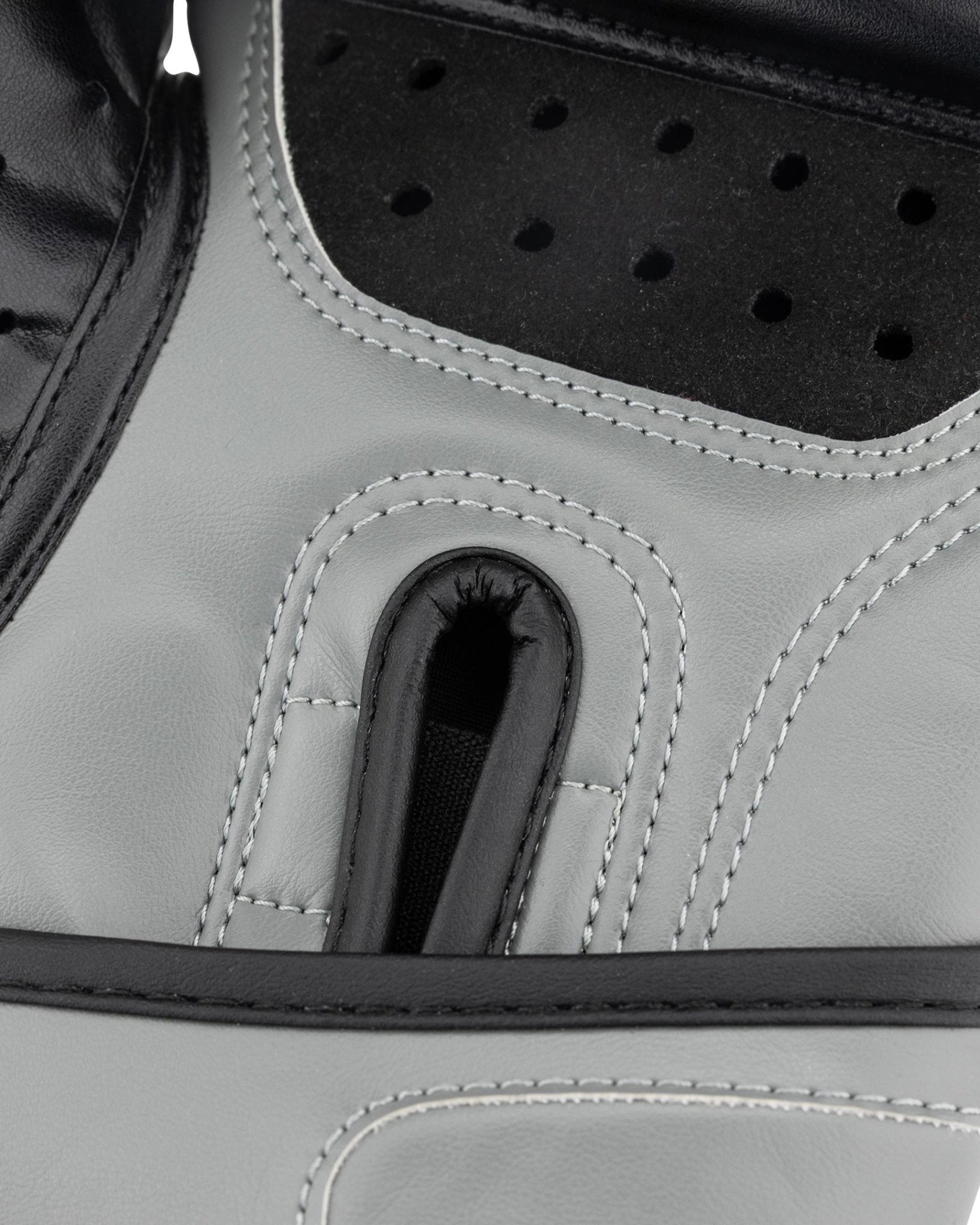 Grey youth heavy bag glove close-up of black perforated palm guard and thumb seam