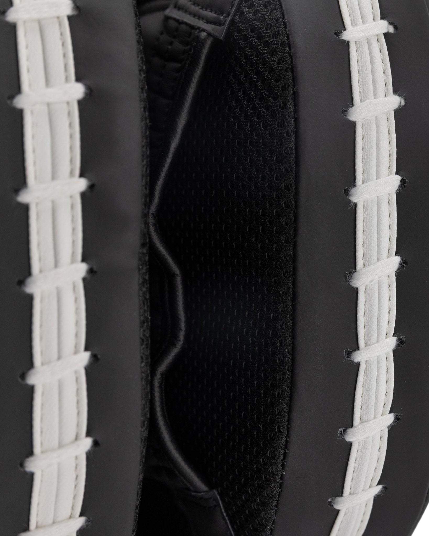 Focus mitt close-up: black interior with curved seams and white lace straps.