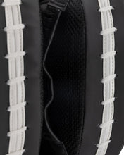 Focus mitt close-up: black interior with curved seams and white lace straps.