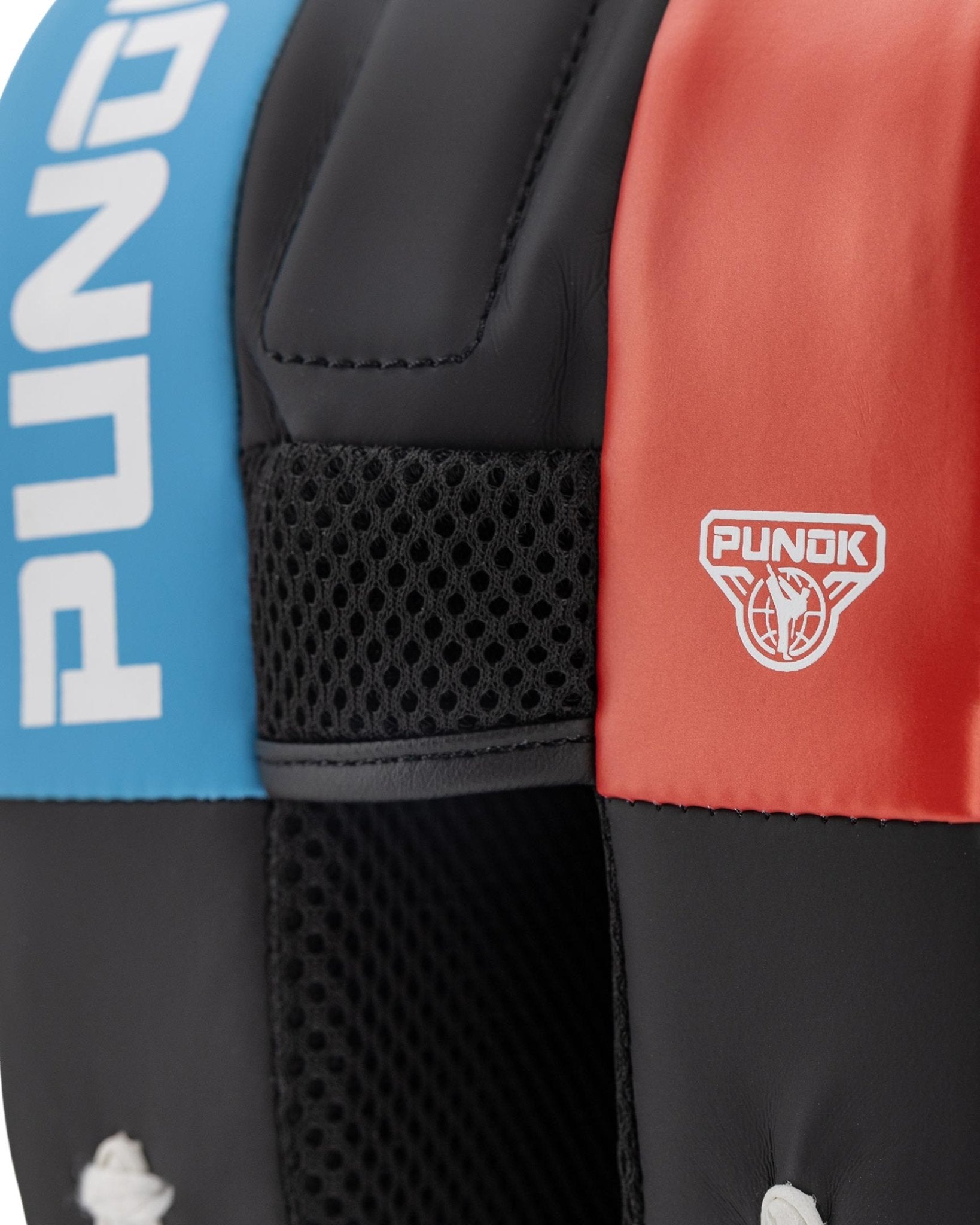 Focus mitt close-up: black perforated panel with blue side and Punok logo patch.