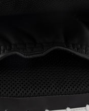 Focus mitt close-up: textured black padding with stitched seam and wavy contour.
